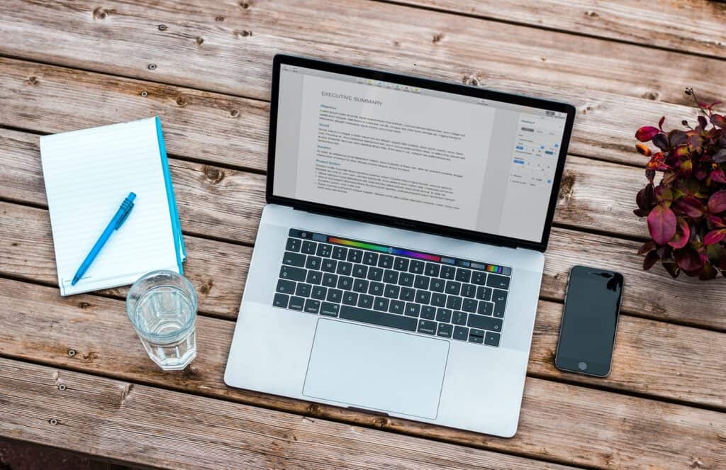 A laptop on a desk with a course outline typed up on it